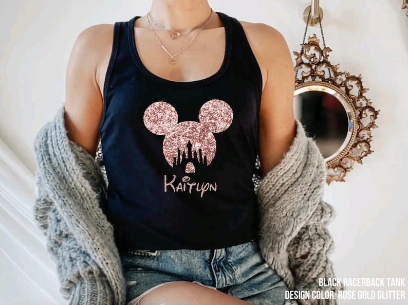 May include: Black racerback tank top with a rose gold glitter Mickey Mouse head and castle design. The text "Kaitlynn" is printed below the design.