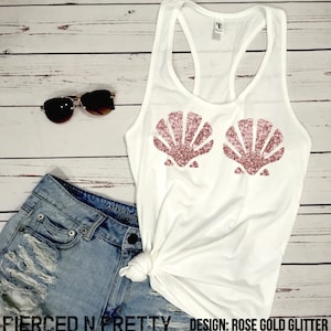 May include: White tank top with rose gold glitter seashell design. The top is paired with denim shorts and sunglasses. The text "Pierced N Pretty" and "Design: Rose Gold Glitter" are visible.