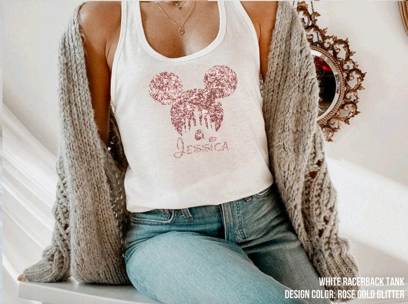 May include: White racerback tank top with a rose gold glitter Mickey Mouse design and the name "Jessica" underneath.