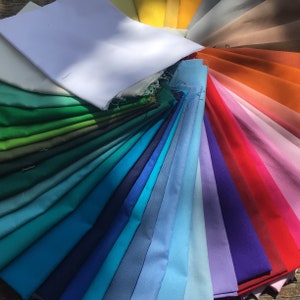 Pu&ograve; includere: Una ruota dei colori di campioni di tessuto in varie tonalit&agrave; di verde, blu, viola, rosa, arancione e marrone. I campioni sono disposti in un motivo circolare, con le tonalit&agrave; pi&ugrave; chiare al centro e le tonalit&agrave; pi&ugrave; scure ai bordi.