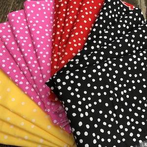 May include: A collection of fabric swatches featuring a polka dot pattern in various colors, including yellow, pink, red, and black.