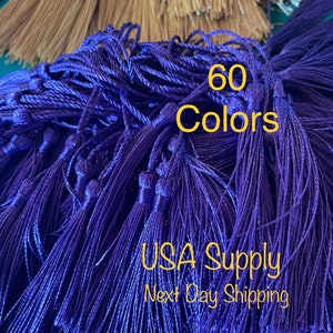 May include: A close-up of a pile of purple tassels. The tassels are made of a soft, silky material and are perfect for adding a touch of elegance to any project. The text "60 Colors" and "USA Supply Next Day Shipping" is visible in the image.