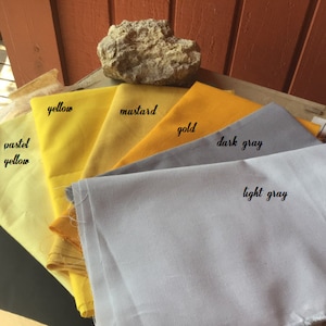 Pu&ograve; includere: Una collezione di campioni di tessuto in diverse tonalit&agrave; di giallo e grigio. I campioni sono etichettati "giallo pastello", "giallo", "senape", "oro", "grigio scuro" e "grigio chiaro".