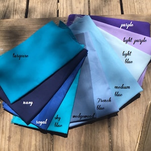 Pu&ograve; includere: Una collezione di campioni di tessuto in diverse tonalit&agrave; di blu, dal turchese al blu chiaro, con alcuni campioni viola. I campioni sono etichettati con i nomi dei colori, tra cui "turchese", "blu navy", "blu reale", "blu cielo", "wedgewood", "blu francese", "blu medio", "blu chiaro", "lilla chiaro" e "viola".