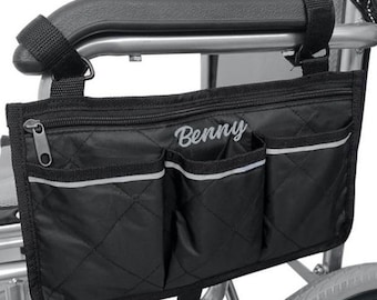 May include: Black wheelchair organizer with multiple pockets and a zippered compartment. The organizer has the name "Benny" embroidered on the front.