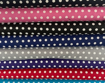 May include: A stack of ten fabric rolls with white polka dots on different colored backgrounds. The colors include black, pink, navy blue, gray, purple, red, turquoise, and hot pink.