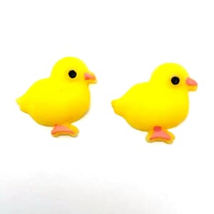 May include: Two yellow chick-shaped embellishments with black eyes and pink beaks and feet. These small, decorative items are likely used for crafts or embellishments, adding a touch of whimsy to various projects.