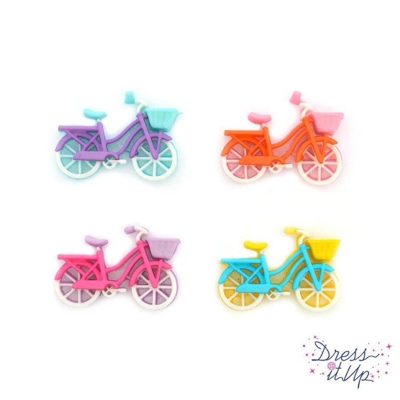 May include: Four colorful bicycle embellishments in purple, orange, pink, and blue. Each miniature bike has a basket and white-rimmed wheels. The bikes are set against a white background.