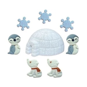 May include: A winter-themed arrangement featuring a white igloo, two penguins with blue and white coloring and scarves, two polar bears with brown scarves, and four blue glitter snowflakes. The objects are arranged on a white background.