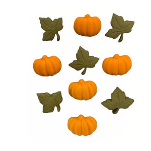 May include: An assortment of orange pumpkin and green leaf embellishments. The pumpkins are a bright orange color and have textured surfaces. The leaves are a muted green and have detailed veining. These decorative elements are perfect for fall-themed crafts.