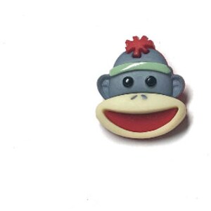 Puede incluir: Una cara de mono de dibujos animados con una boca roja y una cabeza gris. El mono lleva un sombrero gris con un pomp&oacute;n rojo y una diadema verde. La cara del mono es de color beige claro.