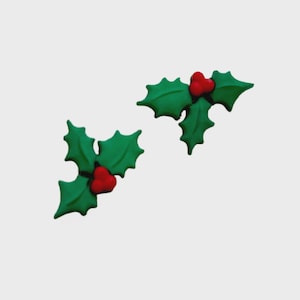 May include: Two green holly leaf clusters with red berries. The leaves have a detailed, textured appearance, and the berries are a vibrant red. The image is set against a plain white background, highlighting the festive, Christmas-themed design.