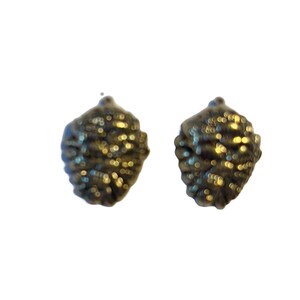 May include: A pair of small, textured earrings shaped like pine cones. The earrings have a dark, metallic finish with a slightly speckled appearance. The jewelry is set against a plain white background.