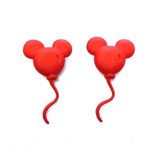 May include: Two red balloon-shaped decorations, each with a Mickey Mouse head design. The balloons have a rounded body with two smaller circles for ears and a curved tail. The background is white.