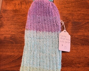Gorro de punto a mano con rayas brillantes y pompón.