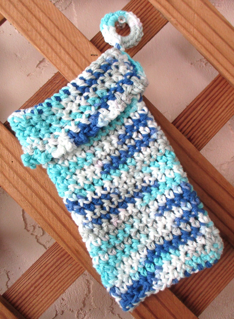 May include: A crocheted phone case in shades of blue, white, and gray. The case has a flap that folds over the top of the phone.