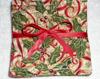 May include: Set of four square fabric coasters with a Christmas holly and ribbon design. The coasters are tied together with a red satin ribbon.