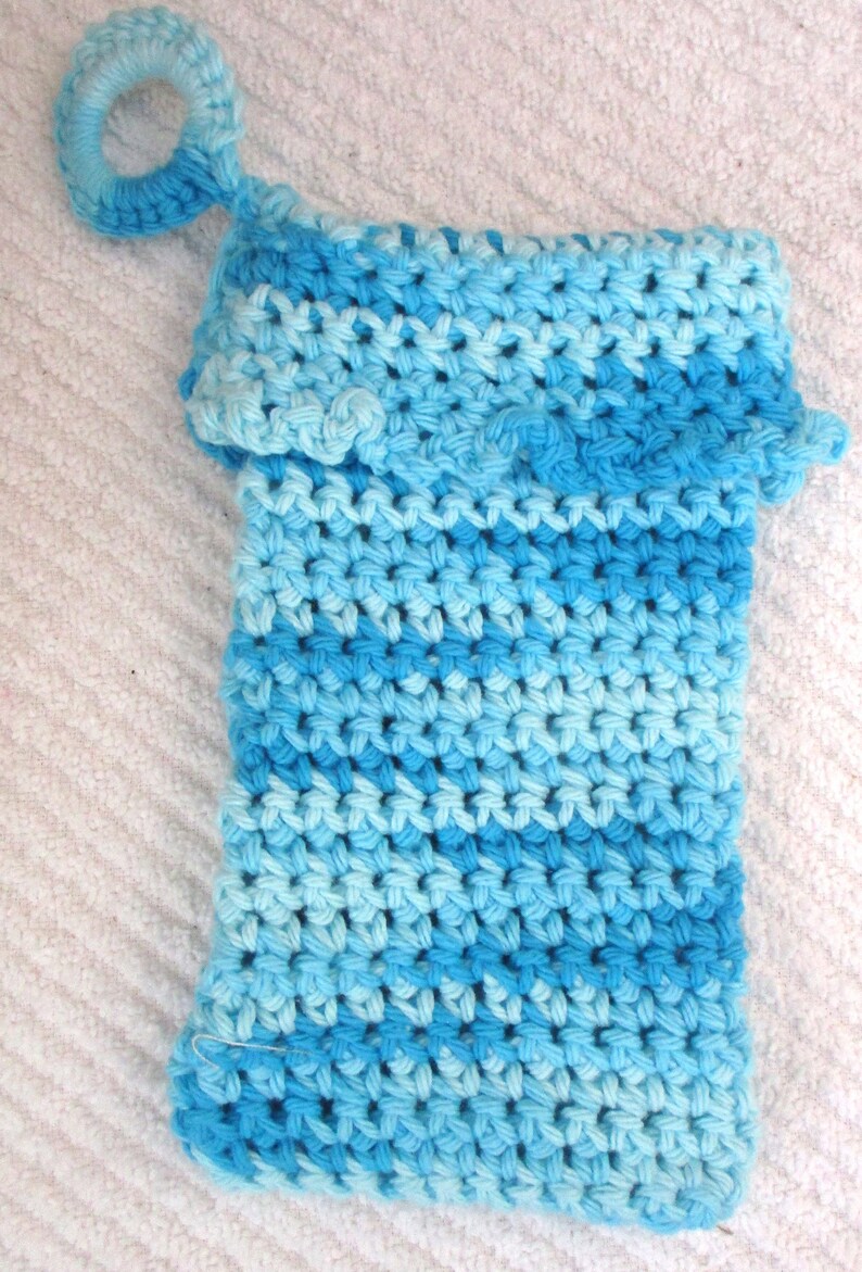 May include: A blue and light blue crocheted washcloth with a crocheted loop handle.
