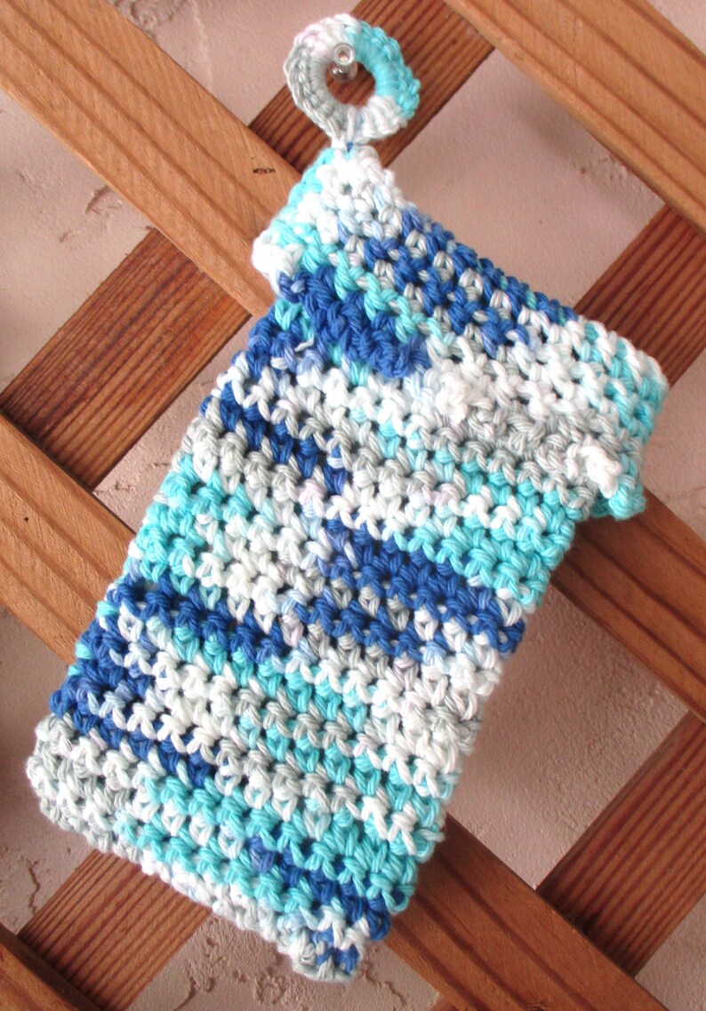 May include: A blue, white, and turquoise crocheted dishcloth with a white loop at the top.