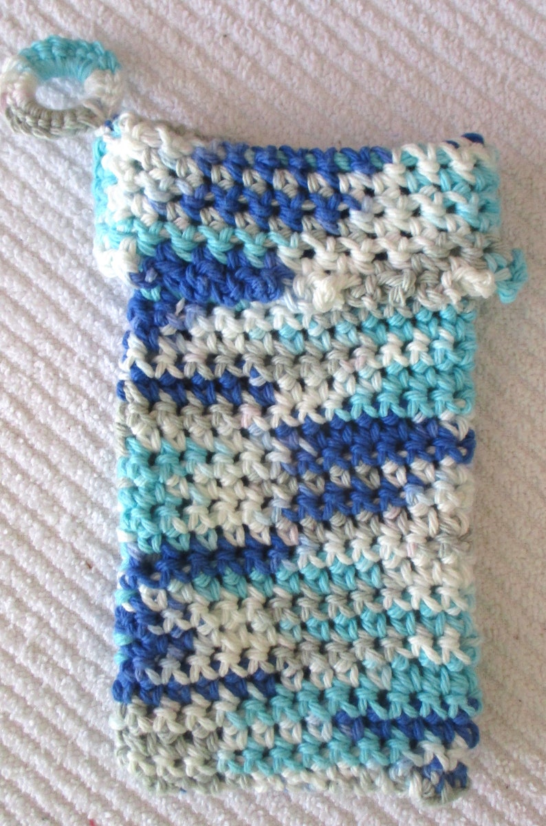 May include: A crocheted blue, white, and gray washcloth with a loop handle.