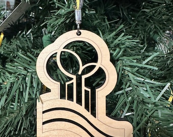 May include: A wooden Christmas ornament with a black silhouette of a stylized tree and the text "Century III Mall 1979-2019".