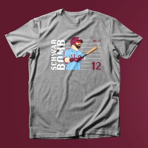 May include: A grey t-shirt with a pixelated image of a baseball player holding a bat. The text "SCHWARB BOMB" is printed on the left side of the image and "DH/LF 12" is printed on the right side of the image.