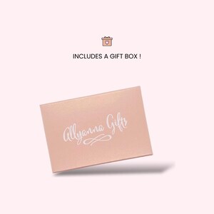 Puede incluir: Una caja de regalo rectangular de color rosa claro con un acabado mate suave. El texto Allyanna Gifts est&aacute; impreso en cursiva blanca en el centro de la tapa, acompa&ntilde;ado de un peque&ntilde;o icono de caja de regalo y el texto INCLUDES A GIFT BOX!