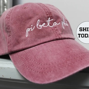 May include: A maroon baseball cap with white embroidered text that reads "pi beta phi".