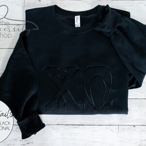 May include: Black sweatshirt with tonal embroidery of the letters "XO" in a script font.