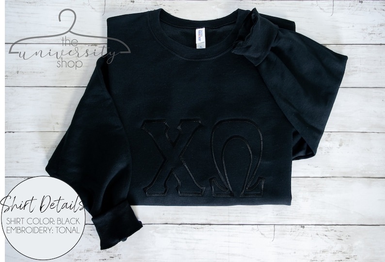 May include: Black sweatshirt with tonal embroidery of the letters "XO" in a script font.
