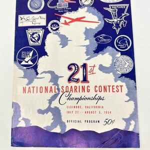 May include: Vintage program cover for the 21st National Soaring Contest Championships in Elsinore, California, 1954. Features a blue and white design with various glider club logos and the text "Official Program 50¢".