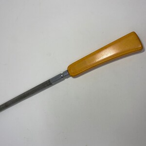May include: A yellow plastic handled metal knife sharpener.