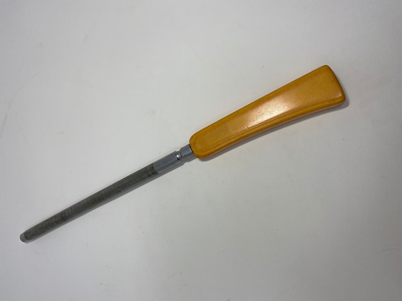 May include: A yellow plastic handled metal knife sharpener.