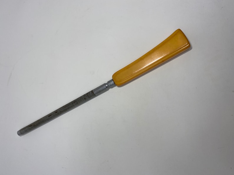 May include: A yellow plastic handle attached to a silver metal knife sharpener.