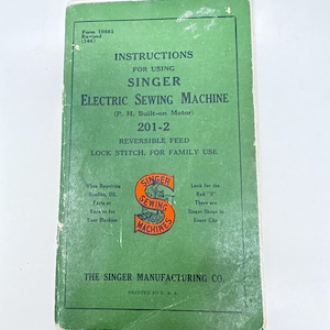 May include: Vintage Singer Electric Sewing Machine instruction manual. The green cover features the Singer logo in orange and white, with text detailing the machine's model and features. Printed in the U.S.A.