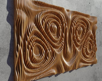 May include: A wooden wall art piece with a 3D design of swirling, layered lines. The piece is made of light brown wood and has a natural, organic look.