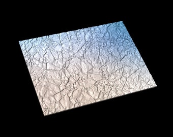 May include: A sheet of silver foil with a textured, crumpled surface. The foil has a gradient of blue and white colours.