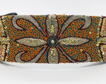 May include: A teal, orange, and gold embroidered headband with sequins and pearl accents.