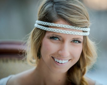 May include: A woman with long blonde hair wearing a silver beaded headband. She is smiling and looking at the camera.