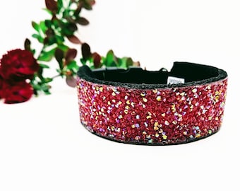 Könnte beinhalten: Ein rotes, mit Schmuck besetztes Hundehalsband mit einer schwarzen, verstellbaren Schnalle. Das Halsband ist mit kleinen roten Kristallen besetzt.