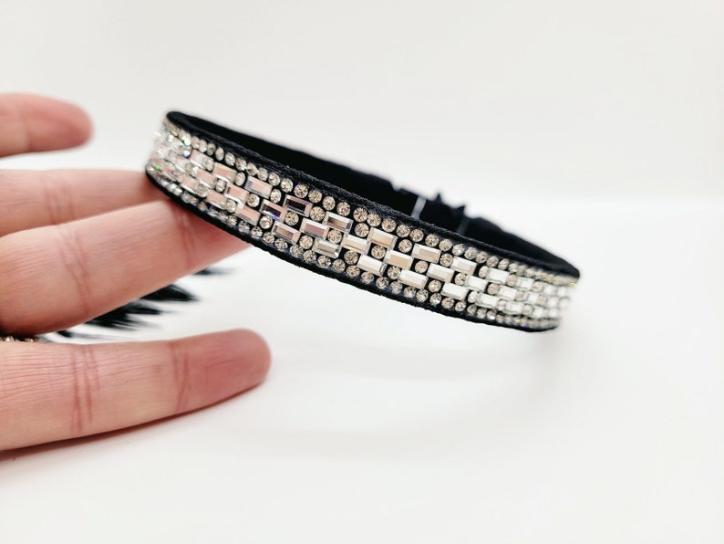 May include: A black velvet choker with a row of clear rectangular rhinestones.