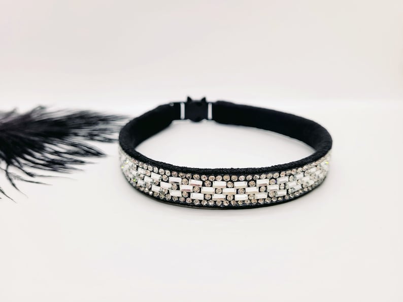 May include: A black headband with a row of clear rhinestones. The headband is made of a soft, stretchy material and is perfect for adding a touch of sparkle to any outfit.