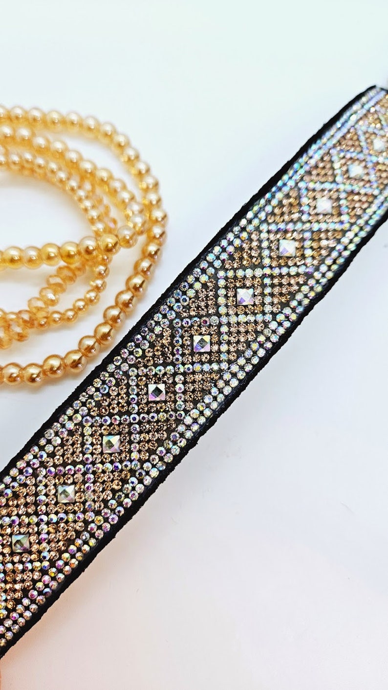 Puede incluir: Un collar gargantilla negro con un patr&oacute;n geom&eacute;trico de diamantes de imitaci&oacute;n iridiscentes. Los diamantes de imitaci&oacute;n est&aacute;n dispuestos en forma de diamante y est&aacute;n engastados en una tela negra.