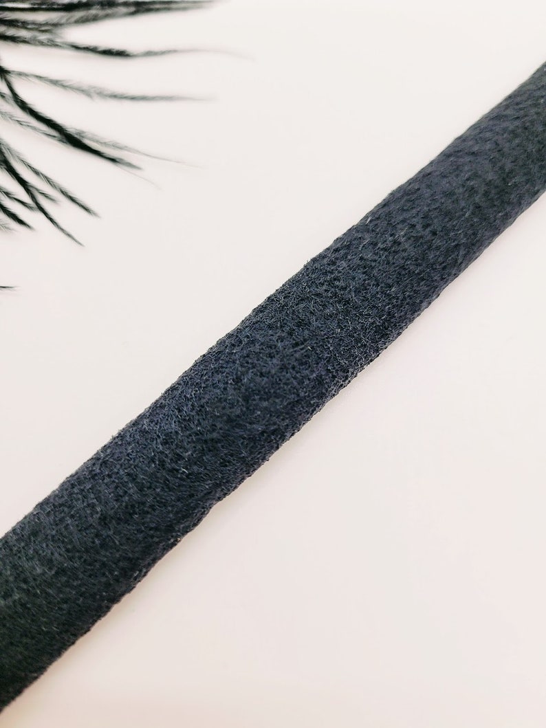May include: A close-up of a black, textured, cord.