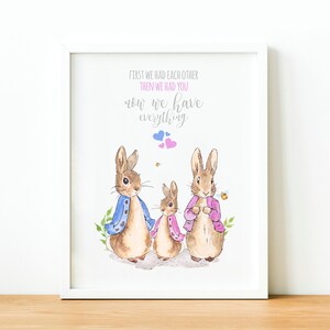 May include: A watercolor illustration of a family of three rabbits with the text "First we had each other, then we had you, now we have everything". The rabbits are wearing blue and pink jackets and are standing on a white background.