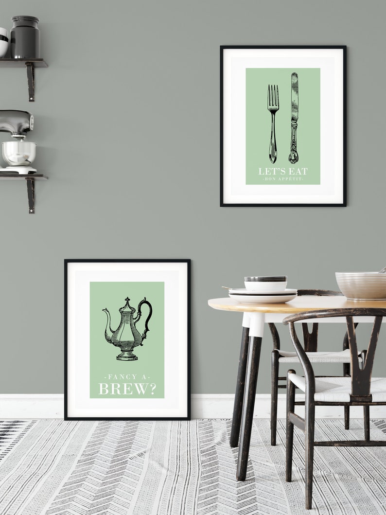May include: Two framed prints with a green background and black illustrations. The top print features a fork and knife with the text "Let's Eat - Bon Appetit". The bottom print features a teapot with the text "Fancy a Brew?"