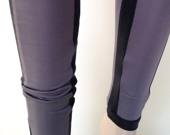 May include: Gray leggings with black side stripes. The leggings are made of a stretchy material and have a close fit.