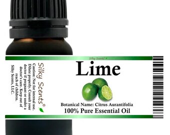 May include: A dark amber glass bottle with a black cap, labeled "Lime." The label features green limes and the text "100% Pure Essential Oil." The brand name "Silky Scents" is also visible.