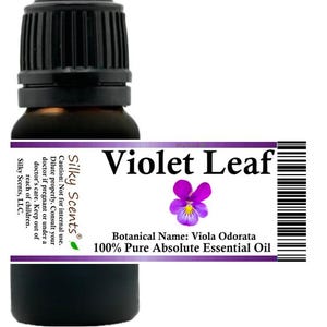 May include: A dark brown glass bottle with a black cap, labeled "Violet Leaf." The label features a purple flower illustration and text indicating it is 100% pure essential oil. The bottle is for aromatherapy and wellness.