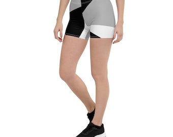 Puede incluir: Shorts deportivos negros, blancos y grises con un patrón geométrico. Los shorts están hechos de una tela elástica y cómoda, perfectos para hacer ejercicio o hacer recados.